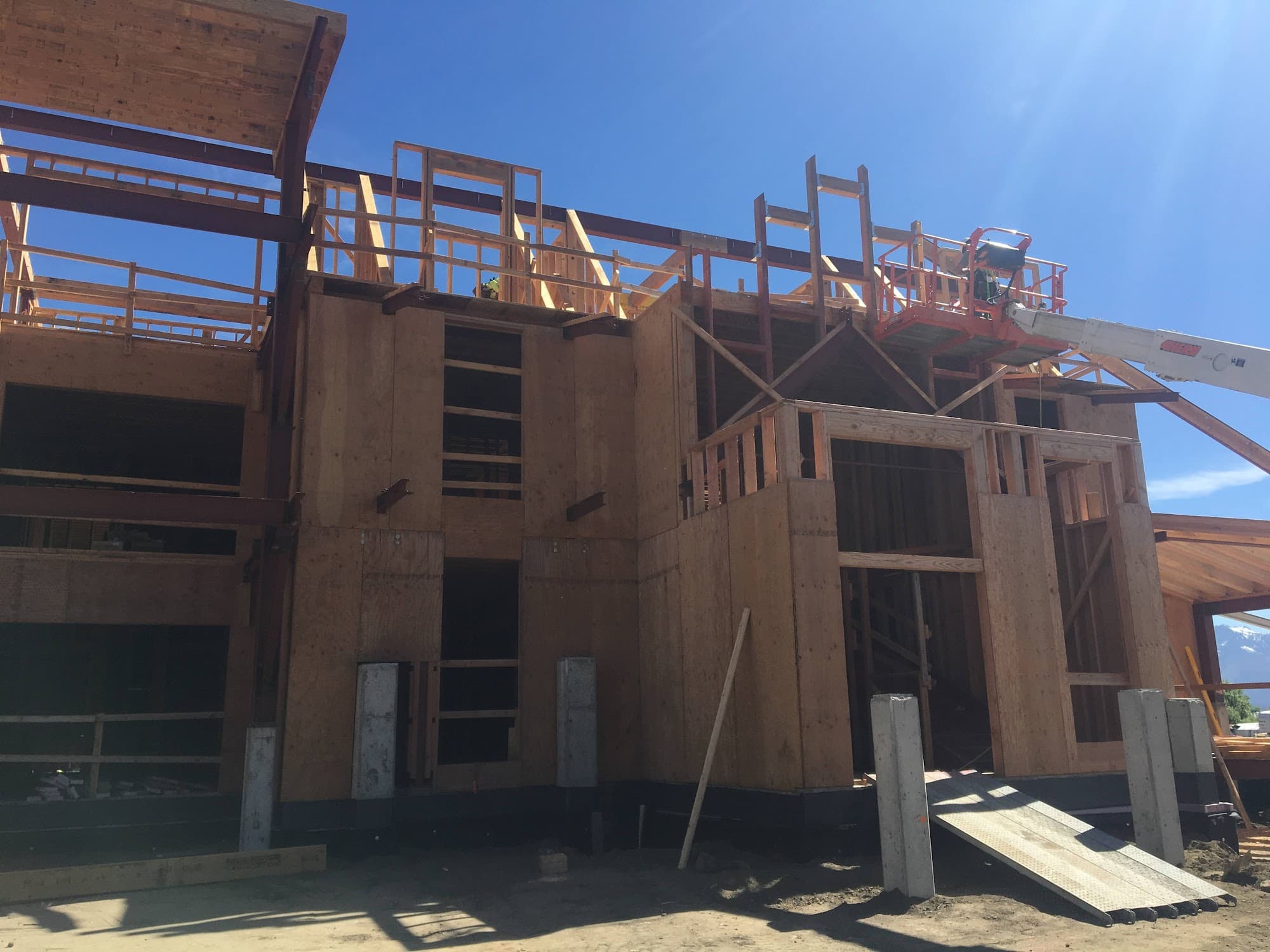 Construction workers on cherry picker at active building site — Palisade Engineering
