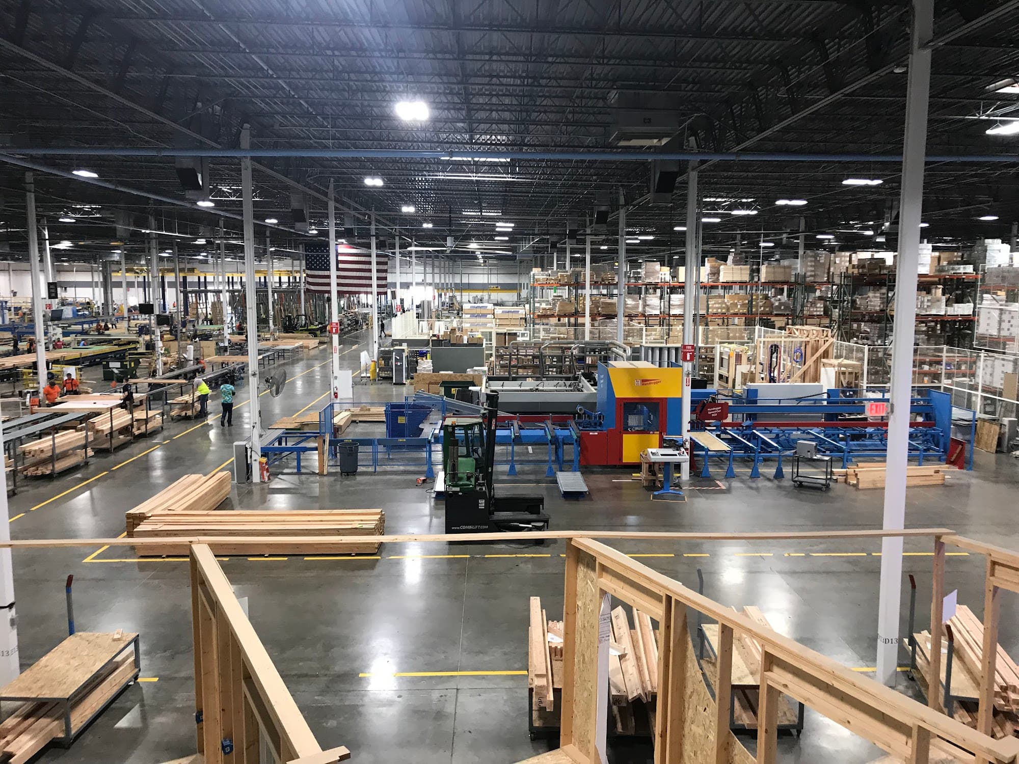 Modular housing factory floor with production lines and wood panel assemblies — innovative multi-family construction