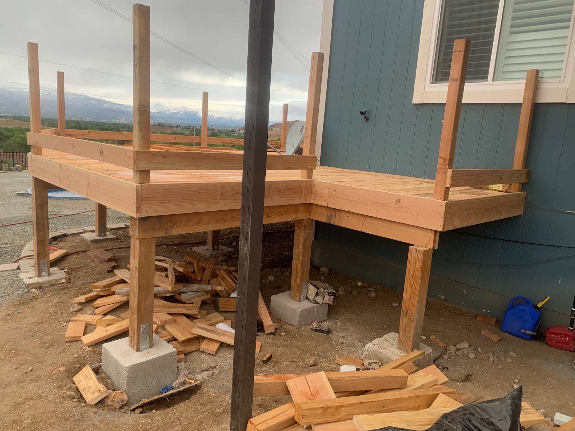 Deck framing under construction with snowy Sierra Nevada mountains in background — Lake Tahoe residential structural engineering